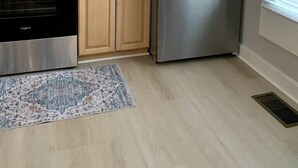Eine Küche mit Holzausstattung, einem Edelstahlkühlschrank, einer Mikrowelle und einem Backofen.