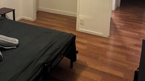 Une chambre à coucher comprenant un lit, une table de chevet, une armoire et une porte donnant sur une autre pièce.