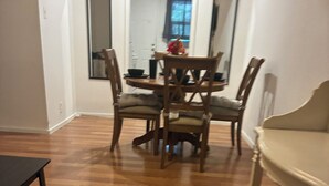 A dining area with a wooden table and chairs, a bench, and a mirror on the wall.