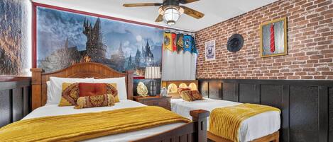 A hotel room with a large bed, a smaller bed, a ceiling fan, a brick wall, and a mural of a castle.