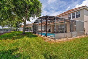 A house with a swimming pool, covered patio, and a large tree. - WH2596 - 6BR House at Windsor Hills Resort (Kissimmee)