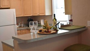 Una encimera de cocina con un plato de comida, dos copas de vino y una botella.