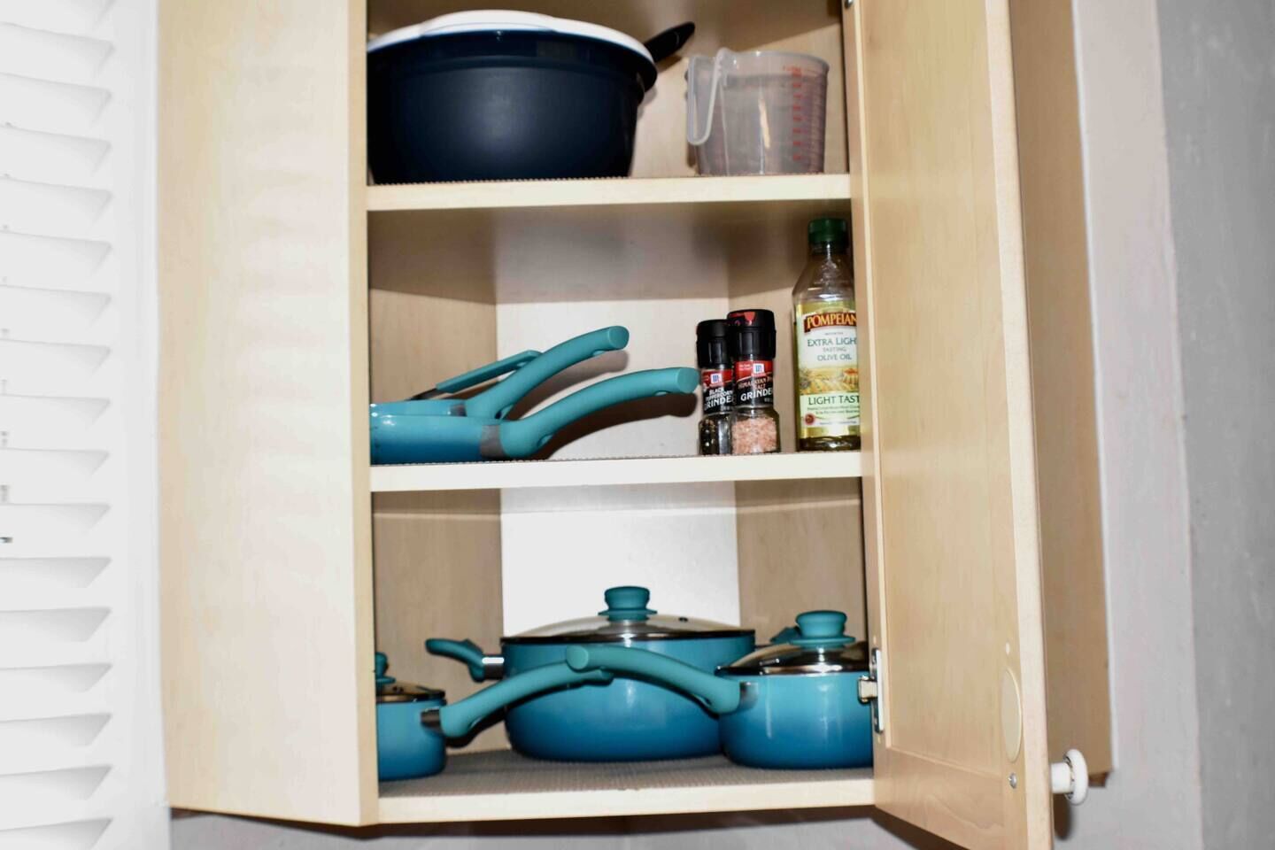 Un armario de madera con estantes que contiene utensilios de cocina y utensilios de cocina.