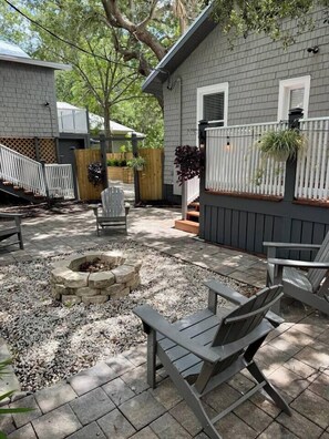 A backyard with a fire pit, outdoor seating, and a wooden fence. - Casa Carrera 2BR/2BA Main Cottage - Walk to Town (St. Augustine)