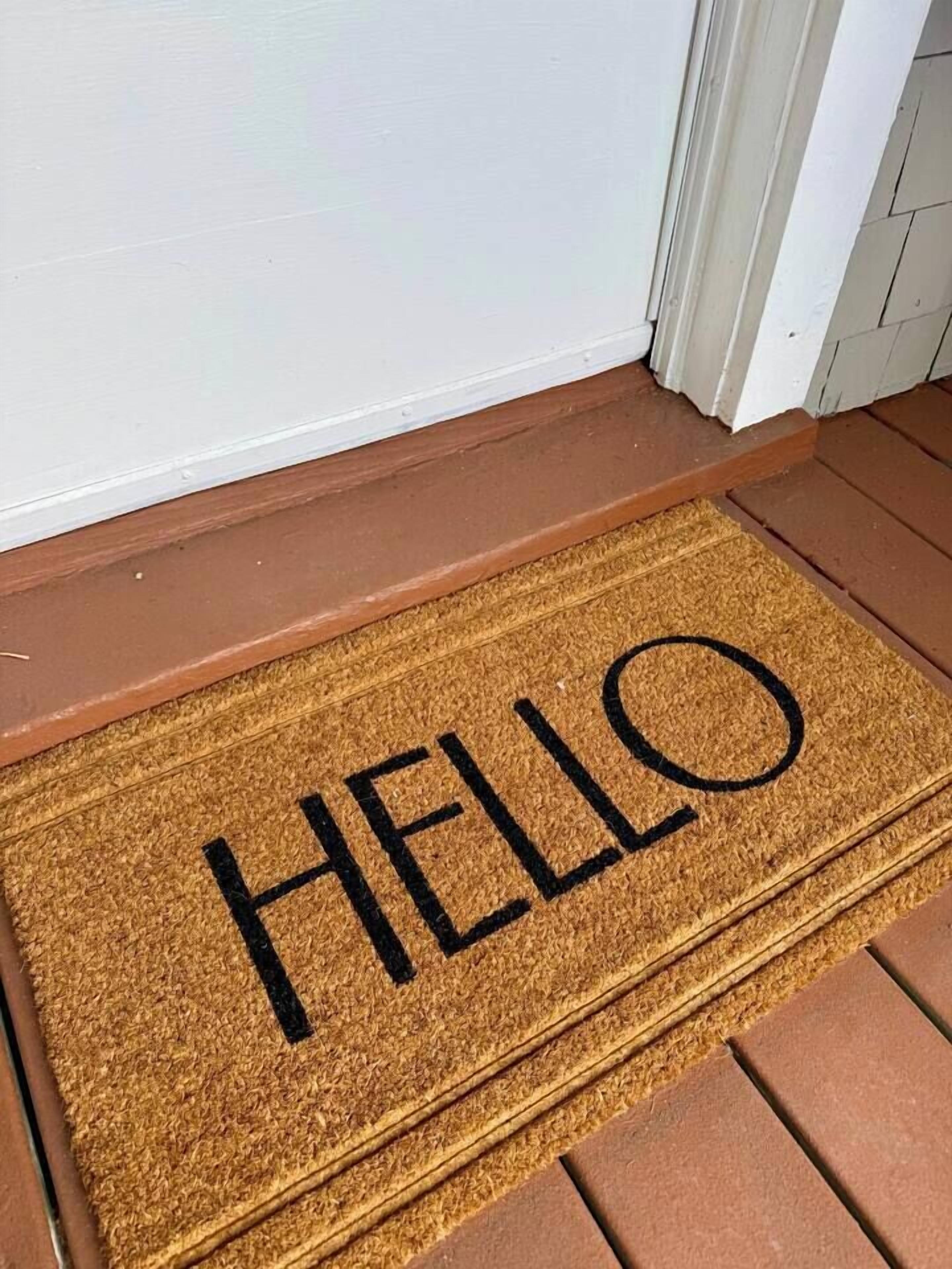 Een deurmat met het woord 'HELLO' in zwarte letters.