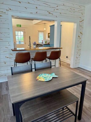 A dining area with a table, four chairs, and a decorative table runner. - 2BR/2B Home-Walk to St. Aug (St. Augustine)