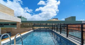 Une piscine sur le toit offrant une vue dégagée sur le ciel et les bâtiments environnants.