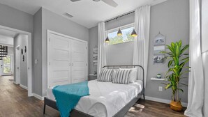 A bedroom with a bed, a ceiling fan, a window with curtains, and a potted plant. - St. Augustine with Private Pool Near Downtown (St. Augustine)