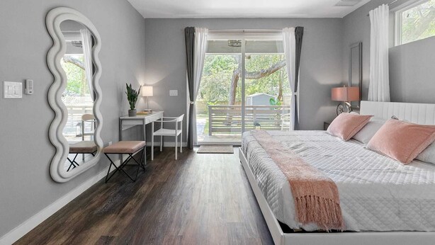 A bedroom with a bed, a desk, a chair, a large mirror, and a ceiling fan. - St. Augustine with Private Pool Near Downtown (St. Augustine)