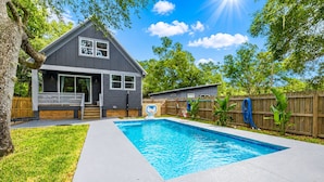 A residential backyard with a swimming pool, a house, and a wooden fence. - St. Augustine with Private Pool Near Downtown (St. Augustine)