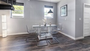 A modern dining area with a glass table, clear chairs, and pendant lighting. - St. Augustine with Private Pool Near Downtown (St. Augustine)