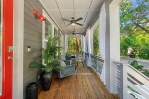 A covered porch with a ceiling fan, seating area, and a view of the surrounding greenery. - St. Augustine with Private Pool Near Downtown (St. Augustine)
