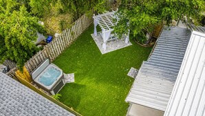 Un pati interior amb un bany d'hidromassatge, una pèrgola i una zona tancada per una tanca.