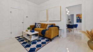 Un saló modern amb un sofà, una taula de centre i obra d'art a la paret.