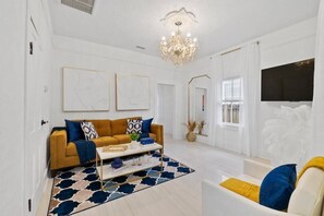 Bright designer living room with chandelier, bold accents, and TV - St. Augustine | Hot Tub | Parking | Walk Downtown (St. Augustine)