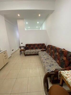 A room with a sofa set, a small table, and a cabinet. - Aura Holiday Home - Golem (Golem)
