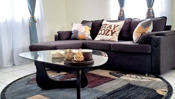 Un salon avec un canapé, une table basse et un tapis.