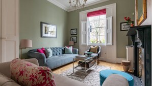 A living room with a sofa, armchairs, a coffee table, and a fireplace. - Remington Street - Four Bedroom Apartment, Sleeps 6 (London)
