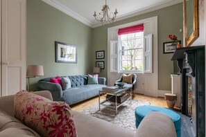 Ein Wohnzimmer mit einer Couch, Sesseln, einem Couchtisch und einem Kamin.