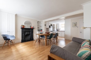 Ein modernes Wohnzimmer mit Kamin, Essbereich und Küche.