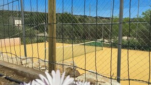 A fenced outdoor area with a basketball court, a basketball hoop, and a wooden post. - Casa La Torre Arriate by Ruralidays (Málaga)