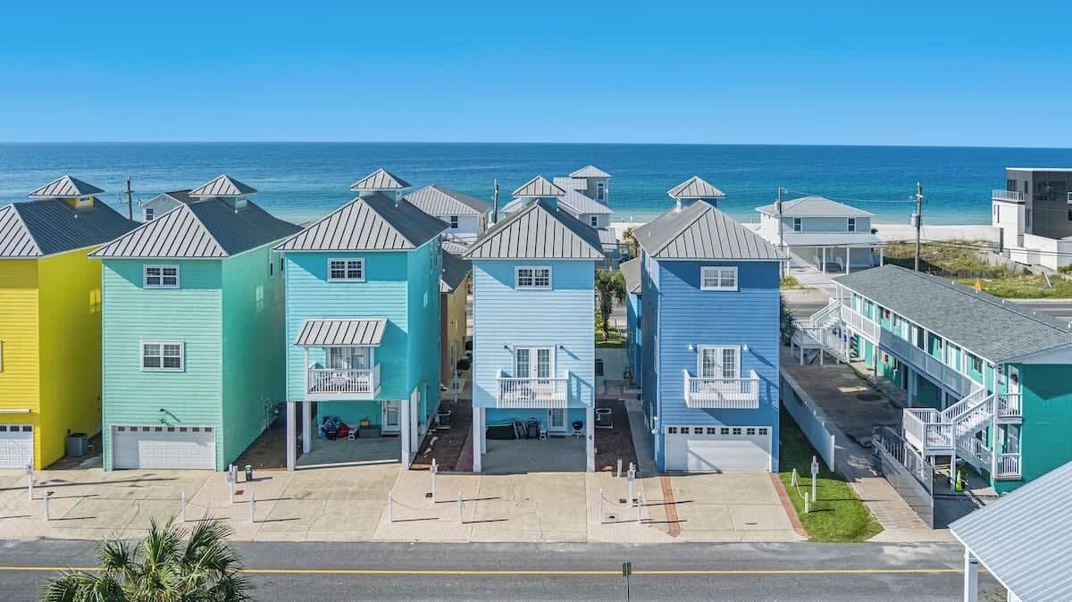 Fileira de edifícios coloridos à beira-mar, com vista clara para o oceano.