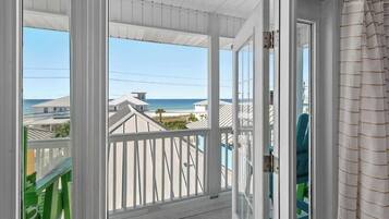 Vista desde una habitación con balcón que da a una playa y al océano.