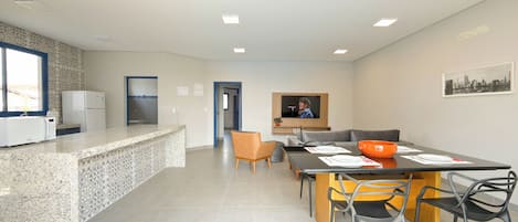 A modern kitchen with a granite countertop, a built-in microwave, and a refrigerator.