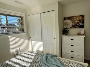 A bedroom with a bed, a white wardrobe, a window with blinds, and a wall decoration. - Ward Lake Retreat - Lake View, Neighborhood Dock & Sports Court (Olympia)