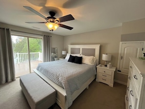 A bedroom with a bed, a nightstand, a dresser, a ceiling fan, and a balcony. - Ward Lake Retreat - Lake View, Neighborhood Dock & Sports Court (Olympia)