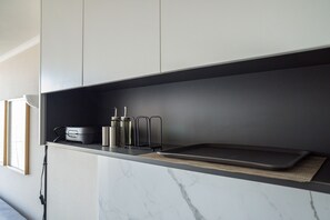 A kitchen with a marble countertop, a black tray, and stainless steel appliances. - Apartment Nearby Metro with Pool (Ñuñoa)