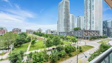 A high-rise building complex with multiple floors, surrounded by green spaces and a clear sky.