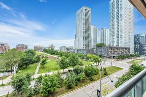 A high-rise building complex with multiple floors, surrounded by green spaces and a clear sky.