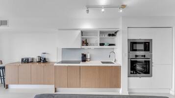 A modern kitchen with a central island, built-in appliances, and a minimalist design.
