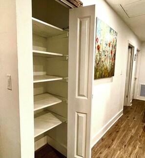 A hallway with a white door leading to a room with a wooden floor. - House of Gems Relax & Unwind Beautiful Atlanta Home for Families & Groups (Atlanta)