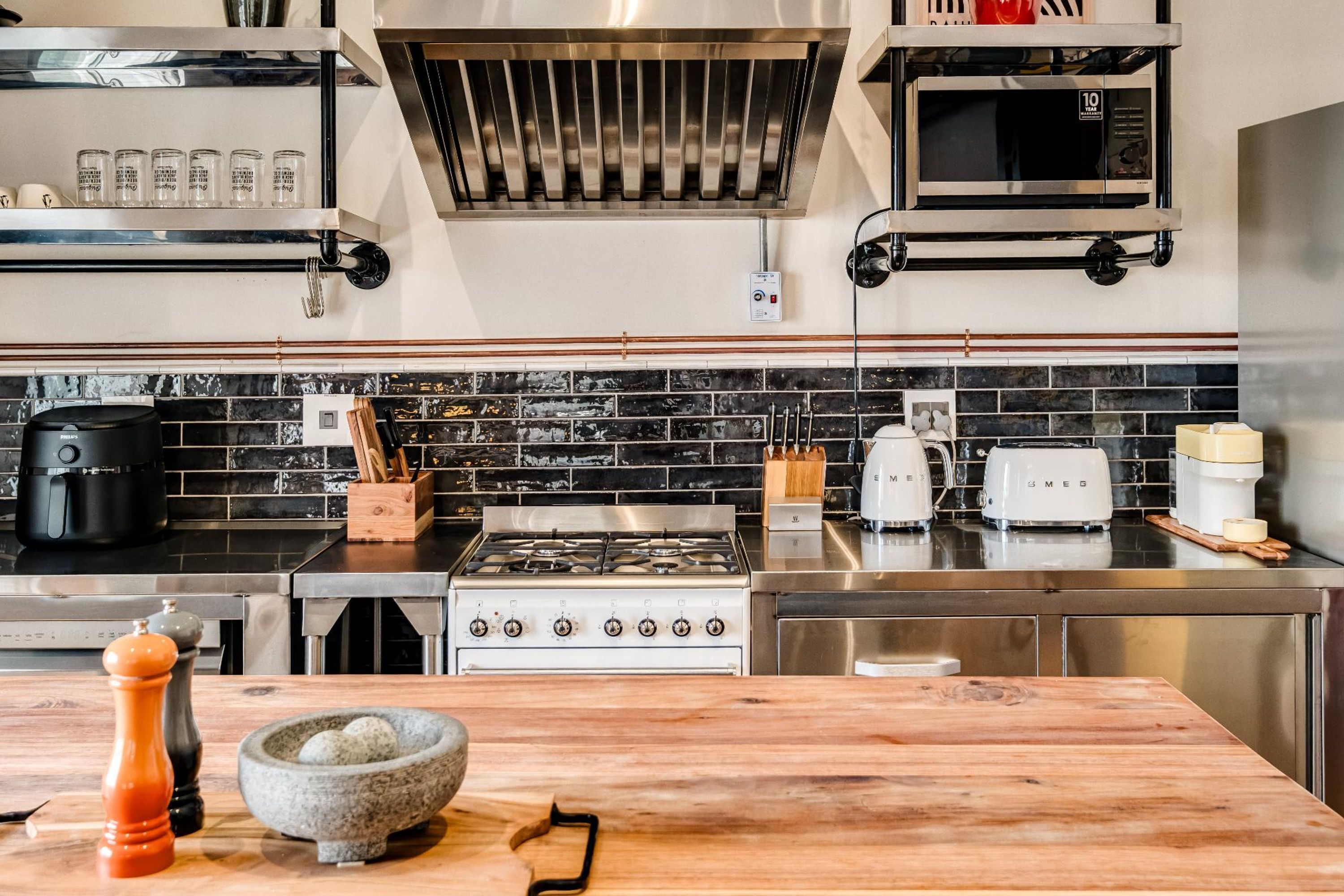 Eine moderne Küche mit Gasherd, Mikrowelle und Kaffeemaschine.