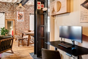 A modern workspace with a computer desk, a wooden table, and chairs. - Central City 2bed With Mountain Views Skywood Loft (Cape Town)