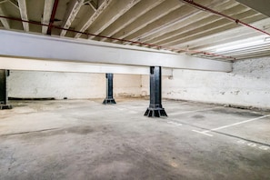 Un estacionamiento vacío con pisos de hormigón y columnas de metal.