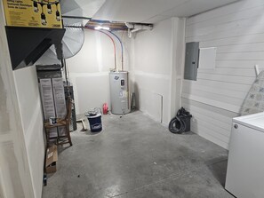 A utility room with exposed pipes, a water heater, and a laundry area. - Sunny Threshold
Spacious 4-bedroom house in quaint Helena with cool AC (Helena)