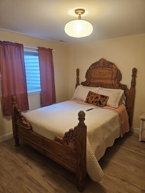 A bedroom with a wooden four-poster bed, a window with curtains, and a ceiling light fixture. - Sunny Threshold
Spacious 4-bedroom house in quaint Helena with cool AC (Helena)