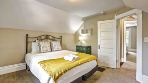 Ein Schlafzimmer mit einem Bett, einer Nachttischlampe, einer Tür und einer Deckenleuchte.