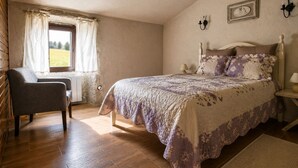 A bedroom with a bed, a chair, a window with curtains, a wall-mounted lamp, and a framed picture. - Schist Houses - Casa da Capela (2-Bedroom House) (Bragança)