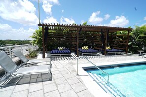 A rooftop pool area with lounge chairs and a pergola. - Top Modern 2BR in Miami - Best location ever! (Miami)