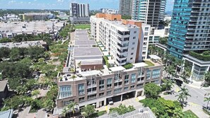 A multi-story building with a rooftop garden, surrounded by other high-rise buildings and greenery. - Top Modern 2BR in Miami - Best location ever! (Miami)