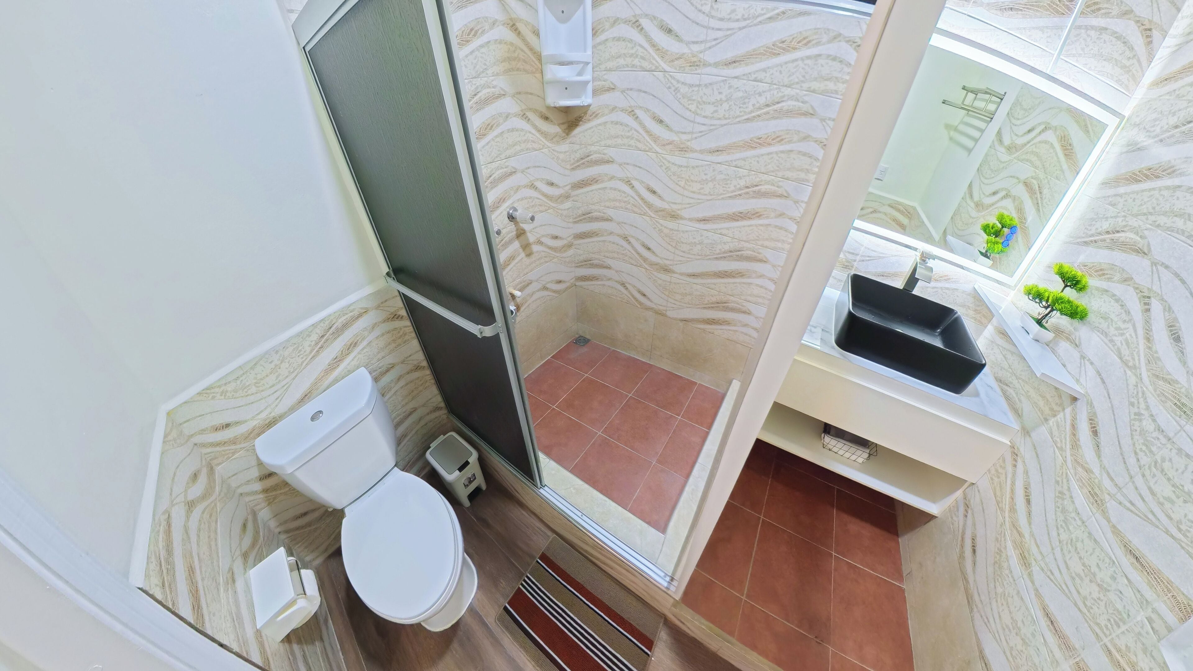 Une salle de bain avec des toilettes, une douche et un lavabo.