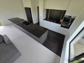 A modern kitchen with a central island, a built-in oven, and a stove. - Come and enjoy some rural views in awesome Taupo (Kinloch)