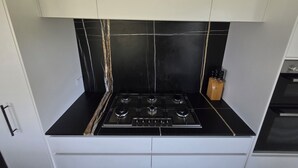 A kitchen with a black tiled backsplash, a gas stove, and white cabinetry. - Come and enjoy some rural views in awesome Taupo (Kinloch)