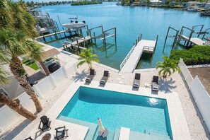 A swimming pool with lounge chairs and a view of a marina. - IRB Coastal Escape, 5BR All En-Suite, Pool & Dock (Indian Rocks Beach)