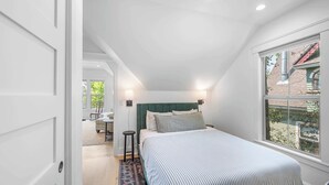 A bedroom with a bed, bedside lamps, a window, and a view of the outside. - Northern Charm with 3BDR & Game Room (Kalispell)