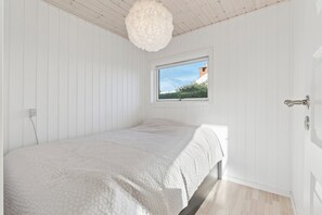 A bedroom with a single bed, a window, and a door. - Cosy holiday home near Kerteminde (Kerteminde)